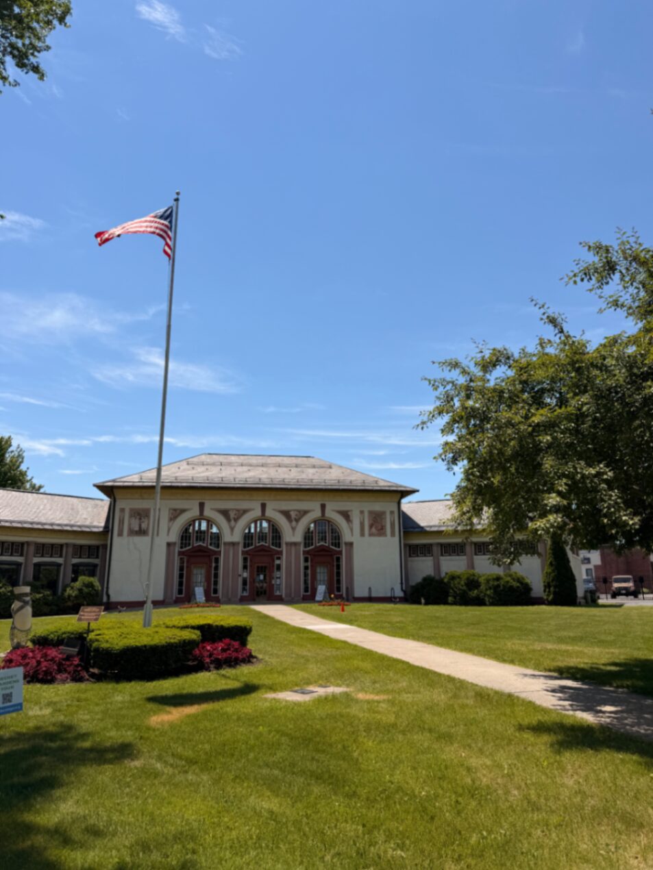 Prédio histórico com bandeira americana e jardim