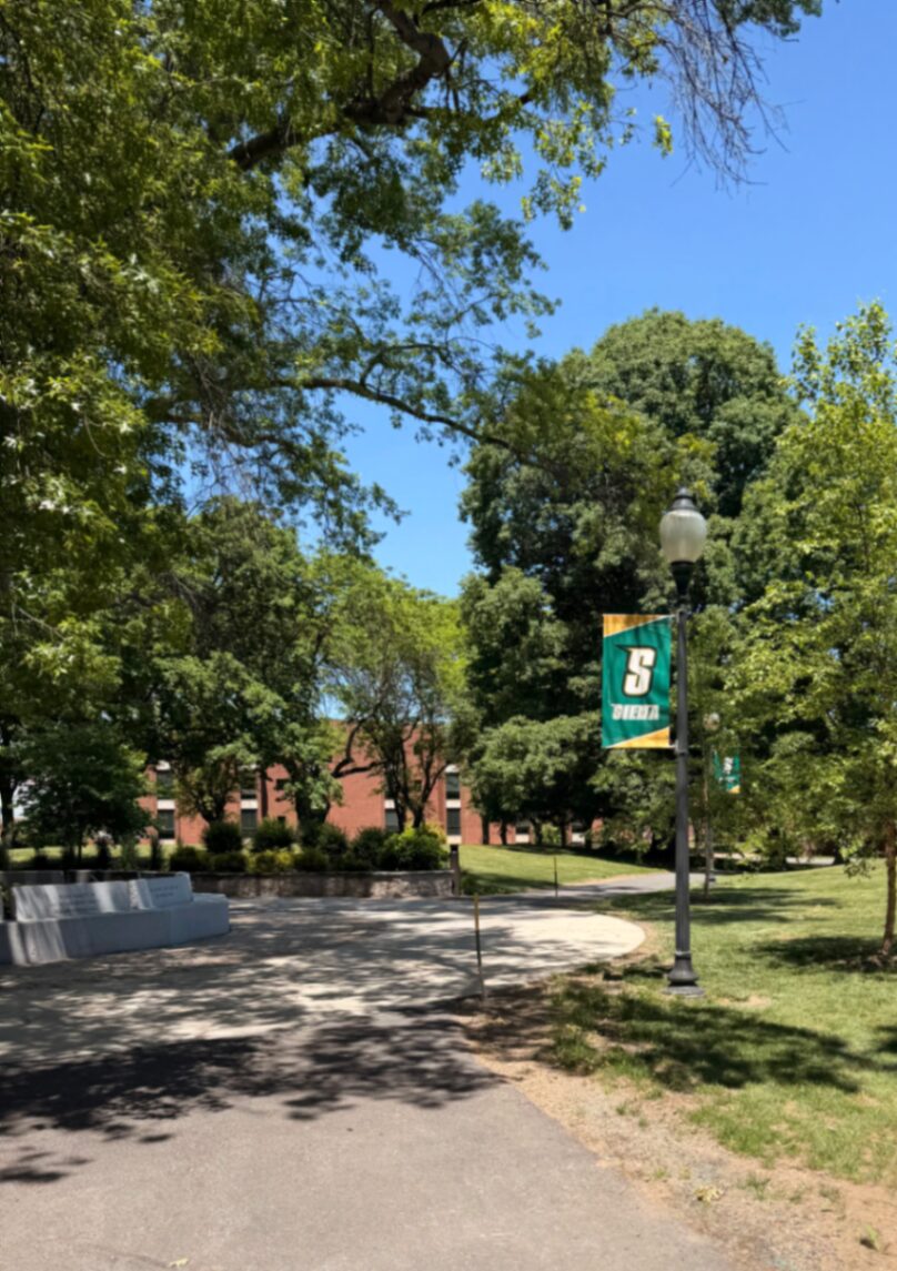 Campus arborizado com bandeira da Siena College